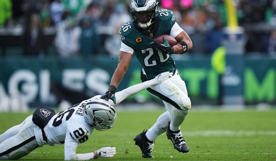 Philadelphia Eagles running back Saquon Barkley (26) runs with the ball past Las Vegas Raiders cornerback Darien Porter (26) during the second half of an NFL football game Sunday, Dec. 14, 2025, in Philadelphia. (AP Photo/Matt Slocum)