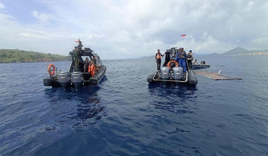 In this photo released by the Indonesian National Search and Rescue Agency (BASARNAS) on Saturday, Dec. 27, 2025, rescuers examine the waters where a debris believed to be from a tour boat that sank was found, near Padar Island within Komodo National Park, Indonesia. (BASARNAS via AP)