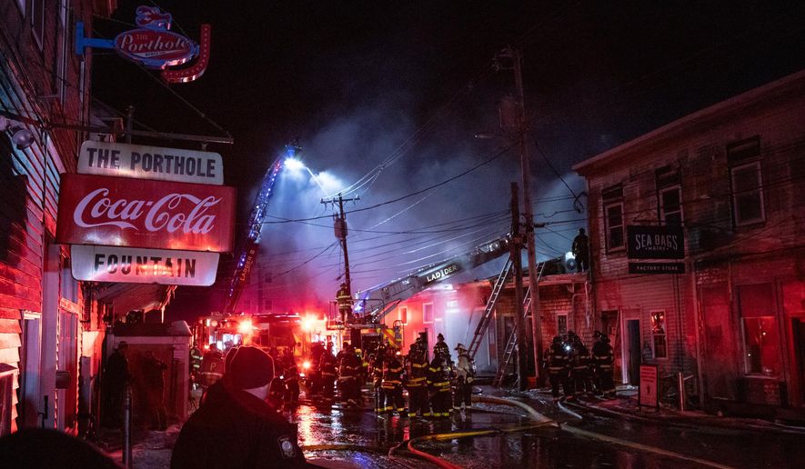Firefighters battle a three-alarm fire on the historic Old Port waterfront late Friday, Dec. 27, 2025 in Portland, Maine. (Libby Kamrowski Kenny/Portland Press Herald via AP)