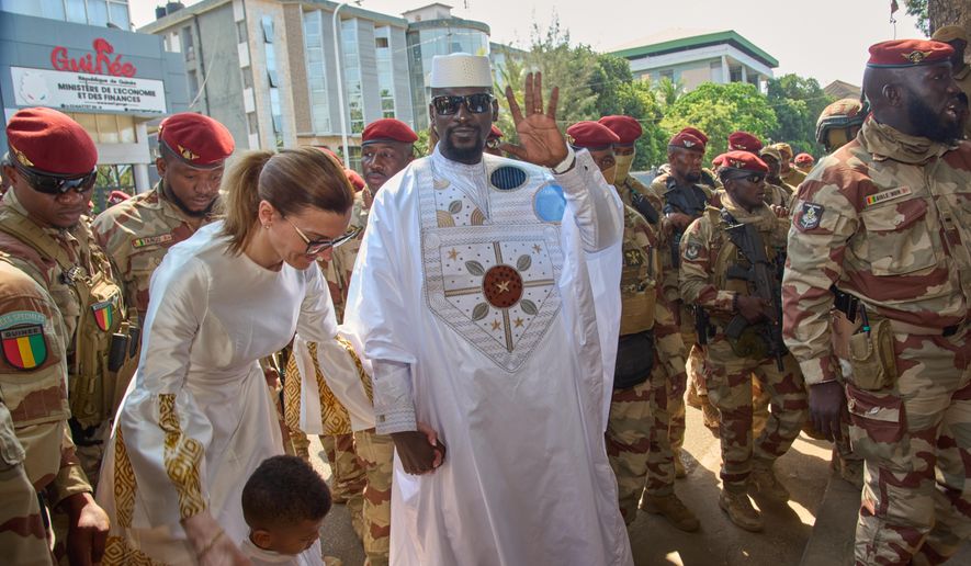 Guinea's President, Gen. Mamadi Doumbouya, arrives with his wife, Lauriane Doumbouya, to cast their votes in the presidential election in Conakry, Guinea, Sunday, Dec. 28, 2025. (AP Photo/Fode Toure)
