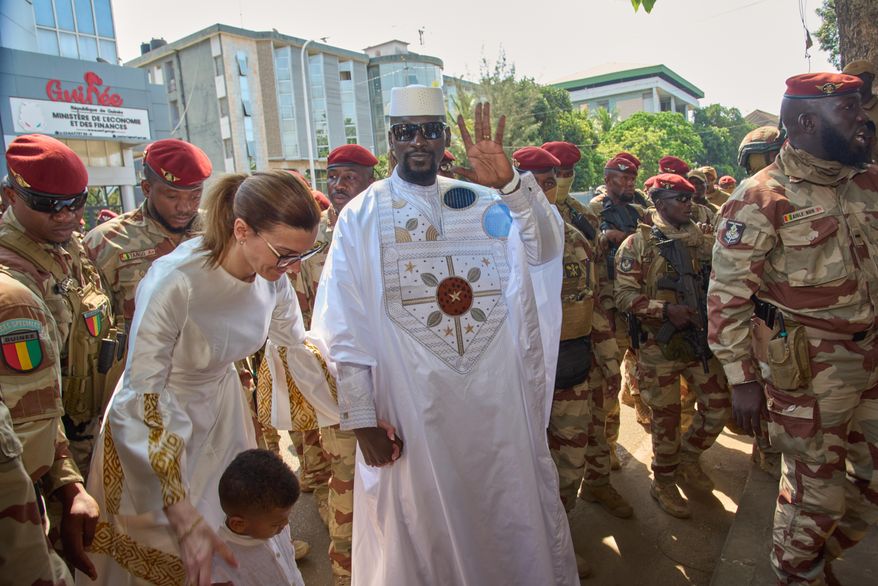 Guinea's President, Gen. Mamadi Doumbouya, arrives with his wife, Lauriane Doumbouya, to cast their votes in the presidential election in Conakry, Guinea, Sunday, Dec. 28, 2025. (AP Photo/Fode Toure)
