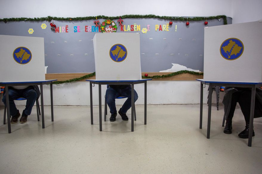 Voters fill their ballots behind voting booths for early parliamentary election in Kosovo's capital Pristina, Sunday Dec. 28, 2025. (AP Photo/Visar Kryeziu)
