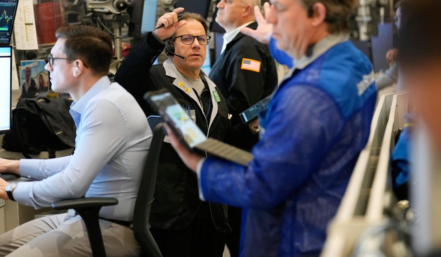 Anthony Spina, center, works on the floor at the New York Stock Exchange in New York, Wednesday, Dec. 10, 2025. (AP Photo/Seth Wenig)