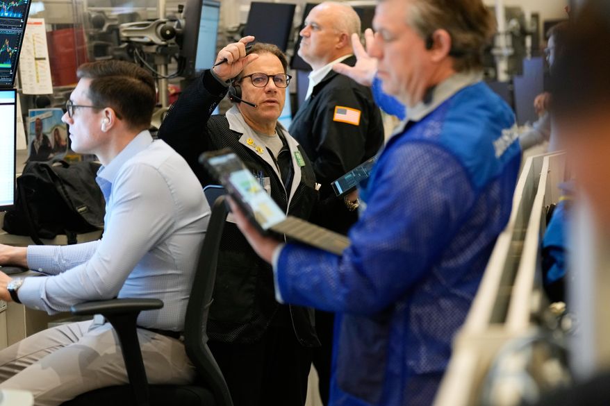 Anthony Spina, center, works on the floor at the New York Stock Exchange in New York, Wednesday, Dec. 10, 2025. (AP Photo/Seth Wenig)