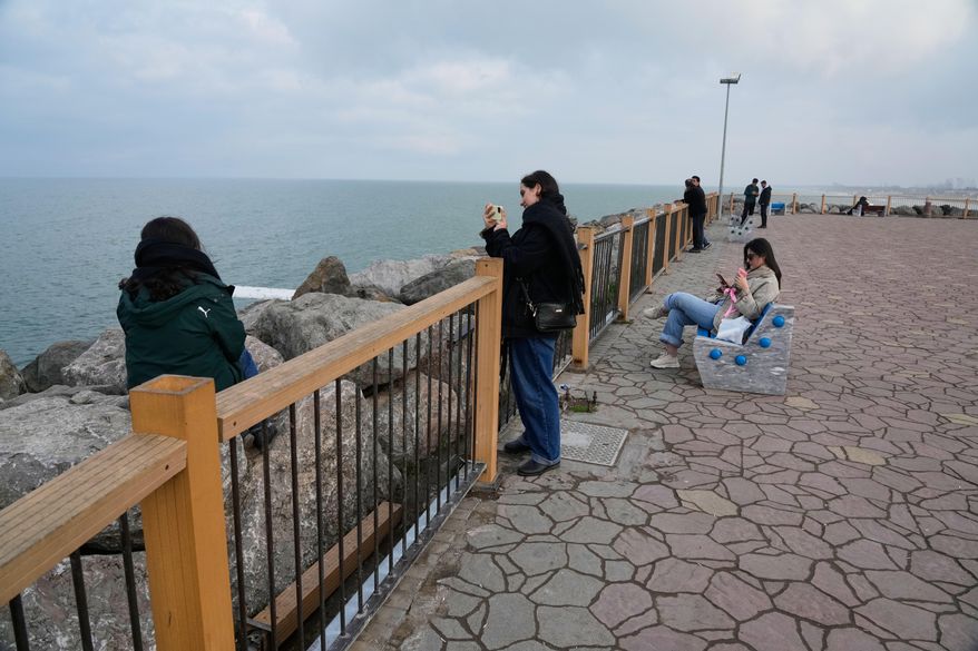 People enjoy their time at the beach of the southern coast of the Caspian Sea outside the port city of Bandar Anzali, Iran, Tuesday, Dec. 23, 2025. (AP Photo/Vahid Salemi) ** FILE **