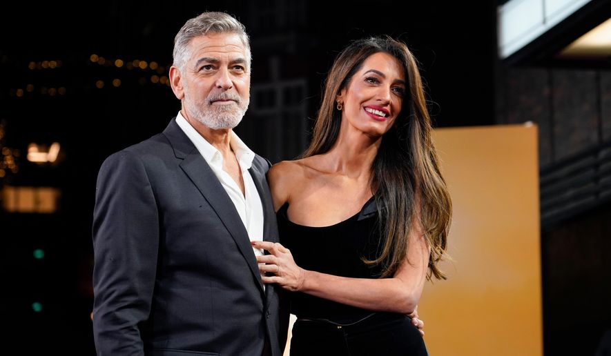 George Clooney and his wife Amal Clooney pose for photographers upon arrival at the screening of the film "The Boys In The Boat," Dec. 3, 2023, in London. (Photo by Alberto Pezzali/Invision/AP, File)