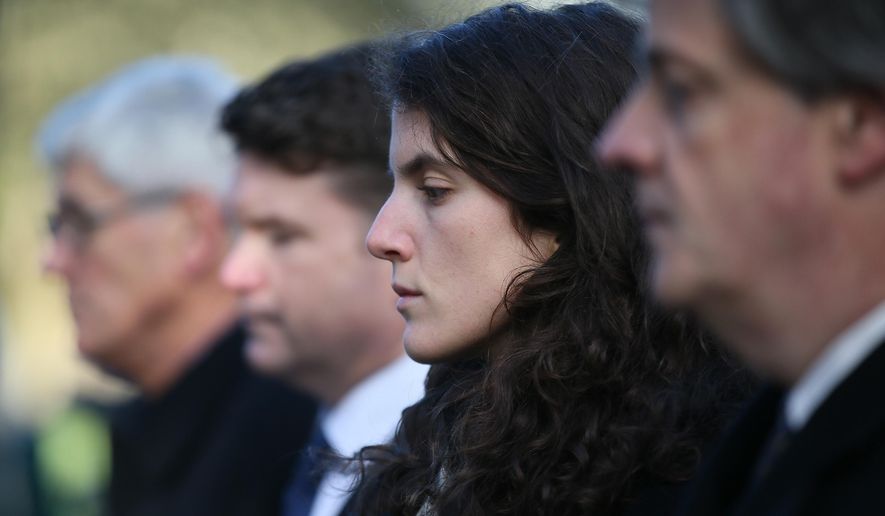 Tatiana Schlossberg, second right, granddaughter of President J.F. Kennedy pauses for a moment of silence during a short ceremony at the JFK memorial Runnymede, England, Friday, Nov. 22, 2013. (AP Photo/Alastair Grant, File)