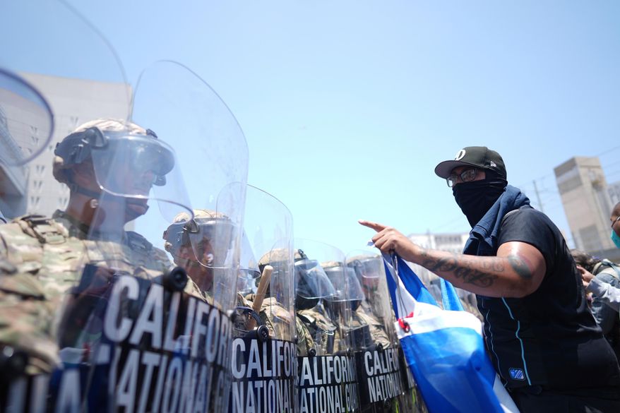 A protester confronts a line of U.S. National Guard members in the Metropolitan Detention Center of downtown Los Angeles, Sunday, June 8, 2025. (AP Photo/Eric Thayer, File)