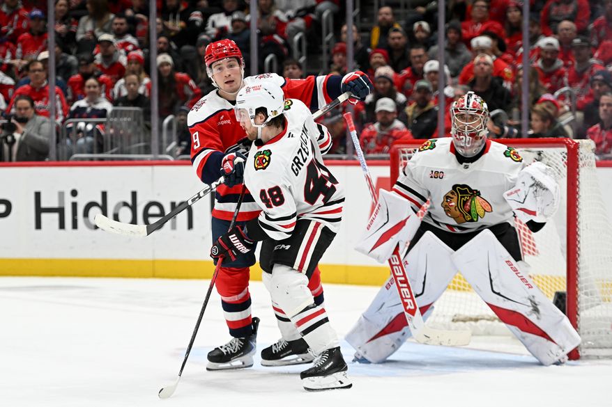 Washington Capitals forward Ryan Leonard (9) clearing out Chicago Blackhawks defenseman Matt Grzelcyk (48) from in front of the net during the third period of an NHL game at Capital One Arena in Washington D.C., January 3, 2026. (Photo for the Washington Times)