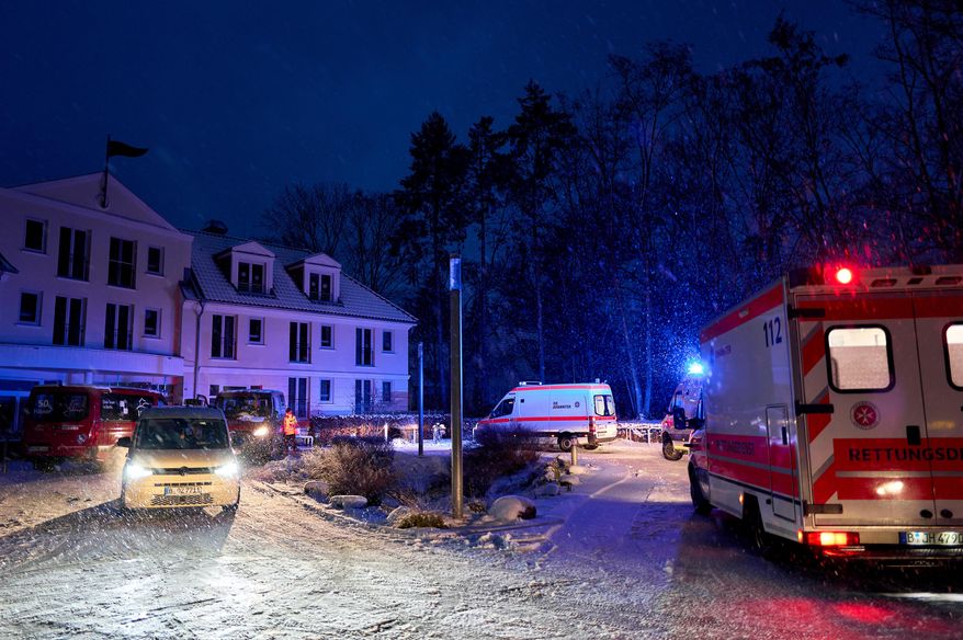 Emergency vehicles from the aid organization "Die Johanniter" pick up residents of a retirement home in Berlin, Germany, Saturday, Jan. 3, 2025, during a power cut in south-west Berlin after a fire on a cable bridge. (Michael Ukas/dpa via AP)