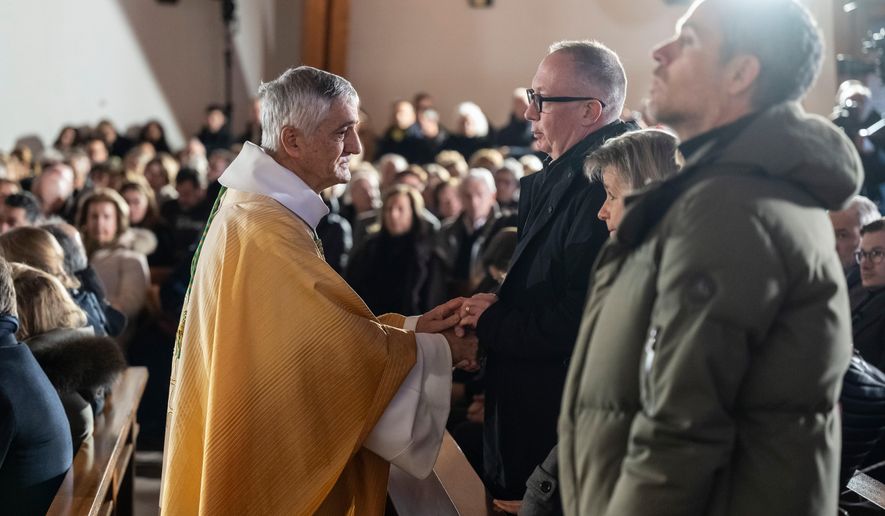 Bishop Monseigneur Jean-Marie Lovey, left, greets Nicolas Feraud, President of Crans-Montana ahead of a Sunday mass at the Chapelle St-Christophe, dedicated to the victims of the fire at the 'Le Constellation' bar and lounge, in Crans-Montana, Switzerland, on Sunday, Jan. 4, 2026. (Jean-Christophe Bott/Keystone via AP)