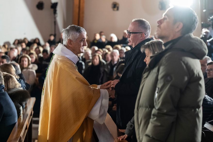 Bishop Monseigneur Jean-Marie Lovey, left, greets Nicolas Feraud, President of Crans-Montana ahead of a Sunday mass at the Chapelle St-Christophe, dedicated to the victims of the fire at the 'Le Constellation' bar and lounge, in Crans-Montana, Switzerland, on Sunday, Jan. 4, 2026. (Jean-Christophe Bott/Keystone via AP)