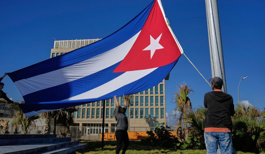 Workers fly the Cuban flag at half-mast at the Anti-Imperialist Tribune near the U.S. embassy in Havana, Cuba, Monday, Jan. 5, 2026, in memory of Cubans who died two days before in Caracas, Venezuela during the capture of Venezuelan President Nicolas Maduro by U.S. forces. (AP Photo/Ramon Espinosa)