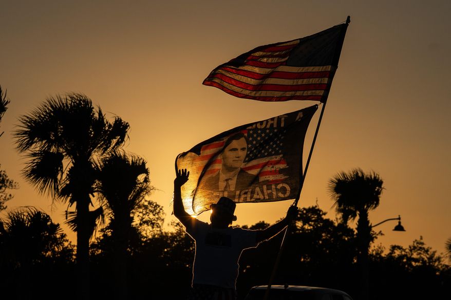 President Trump supporter Steve Emery holds a flag paying tribute to right-wing political activist Charlie Kirk along a bridge to Mar-A-Lago before President Donald Trump departs West Palm Beach, Fla., for Washington, Sunday, Jan. 4, 2026. (AP Photo/Allison Robbert) **FILE**