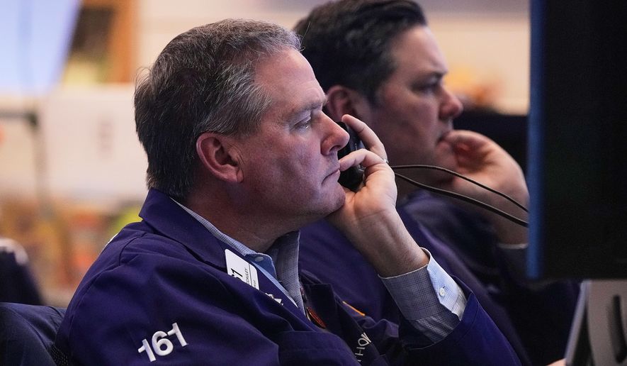 Trader Thomas McCauley, foreground, and a colleague work on the floor of the New York Stock Exchange, Friday, Jan. 2, 2026. (AP Photo/Richard Drew)