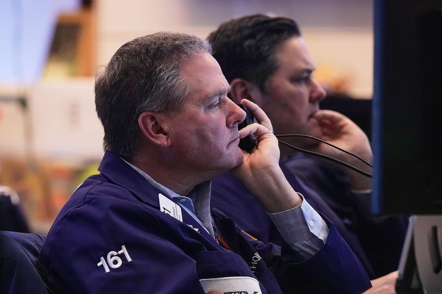 Trader Thomas McCauley, foreground, and a colleague work on the floor of the New York Stock Exchange, Friday, Jan. 2, 2026. (AP Photo/Richard Drew)