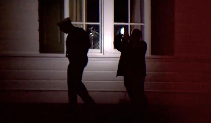 In this image taken from WCPO 9 News video shows officials inspecting broken windows and other property damage at Vice President JD Vance's Ohio home in eastern Cincinnati, Ohio, Monday, Jan. 5, 2026. (WCPO 9 News via AP)
