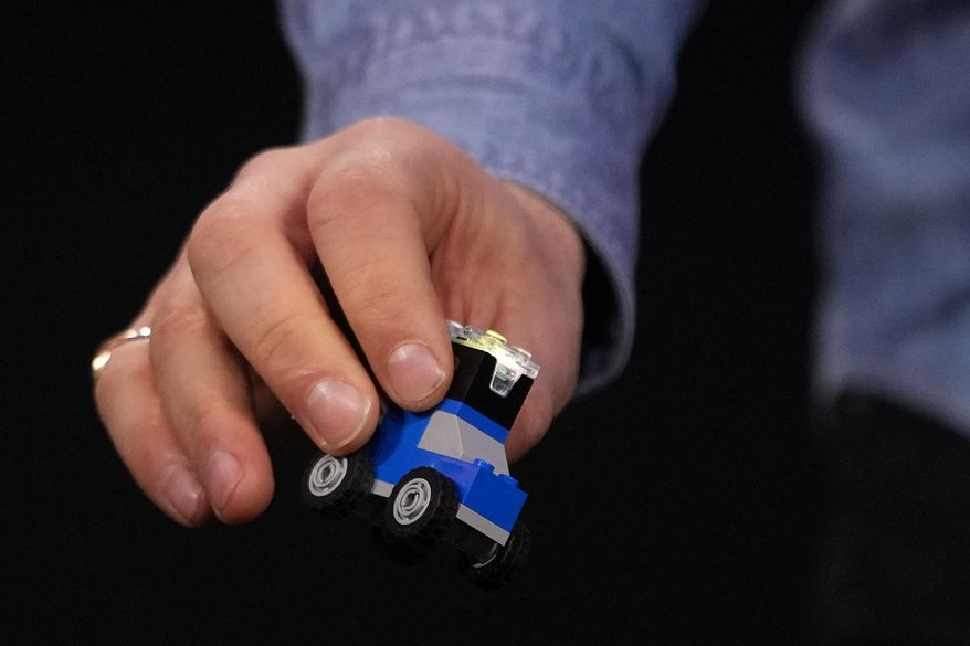 A LEGO piece with a smart brick attached is displayed during a LEGO news conference ahead of the CES tech show Monday, Jan. 5, 2026, in Las Vegas. (AP Photo/Abbie Parr)