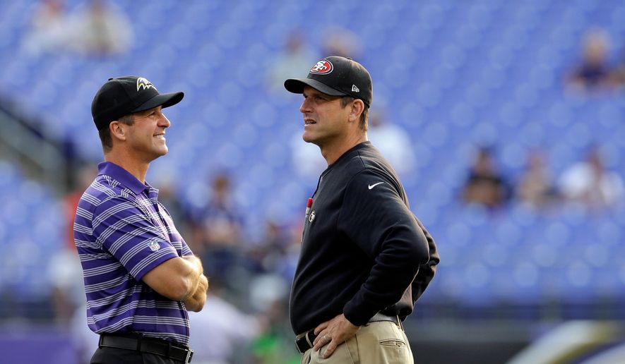 FILE - Baltimore Ravens head coach John Harbaugh, left, and San Francisco 49ers head coach Jim Harbaugh chat before an NFL preseason football game, Aug. 7, 2014, in Baltimore. (AP Photo/Patrick Semansky, File)