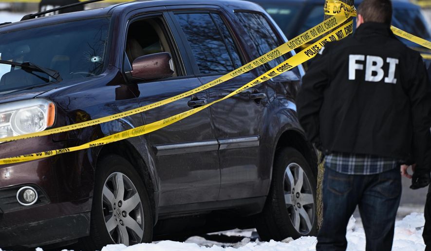A bullet hole is seen in the windshield as law enforcement officers work the scene of a shooting involving federal law enforcement agents, Wednesday, Jan. 7, 2026, in Minneapolis. (AP Photo/Tom Baker)