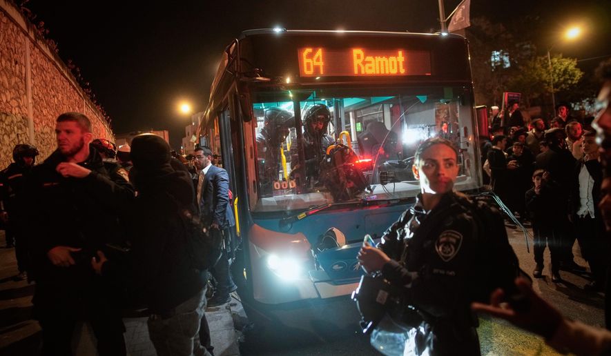 Israeli police inspect a bus following an incident in which it hit ultra-Orthodox Jewish demonstrators blocking a road during a protest against army recruitment in Jerusalem, Tuesday, Jan. 6, 2026. (AP Photo/Ohad Zwigenberg)