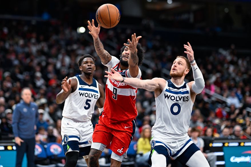 Washington Wizards forward Justin Champagnie (9) lunges for possession of the loose ball with Minnesota Timberwolves guard Donte DiVincenzo (0) at Capital One Arena, Washington, D.C., January 4, 2026. (Photo by Brian Murphy for the Washington Times)