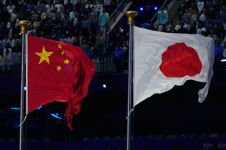 The flags of China and Japan are flown at the during the handover ceremony from China to Japan the next host of the Asian Games at the closing ceremony of the 19th Asian Games in Hangzhou, China, Sunday, Oct. 8, 2023. (AP Photo/Eugene Hoshiko, File)