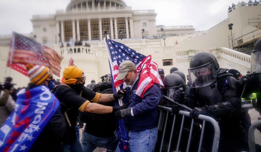 Rioters try to break through a police barrier at the Capitol on Jan. 6, 2021, in Washington. (AP Photo/John Minchillo, File)