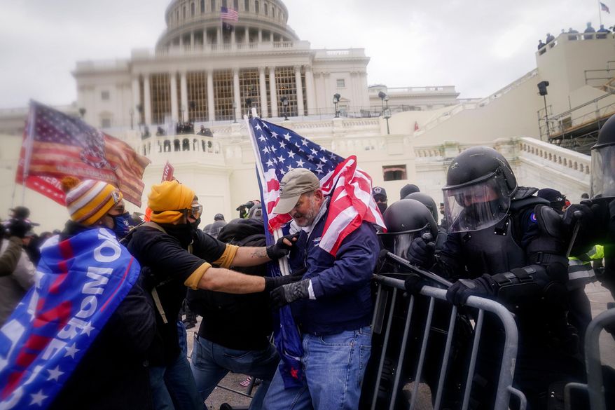 Rioters try to break through a police barrier at the Capitol on Jan. 6, 2021, in Washington. (AP Photo/John Minchillo, File)