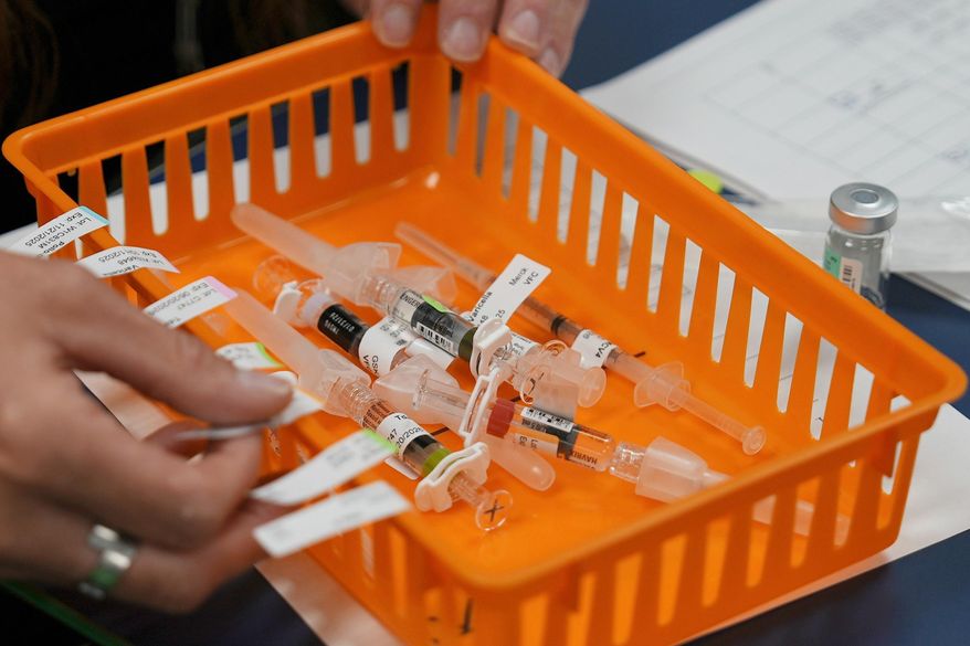 Vaccines are prepared for students during a pop-up immunization clinic at a school in Louisville, Ky., on Thursday, Aug. 8, 2024. (AP Photo/Mary Conlon, File)