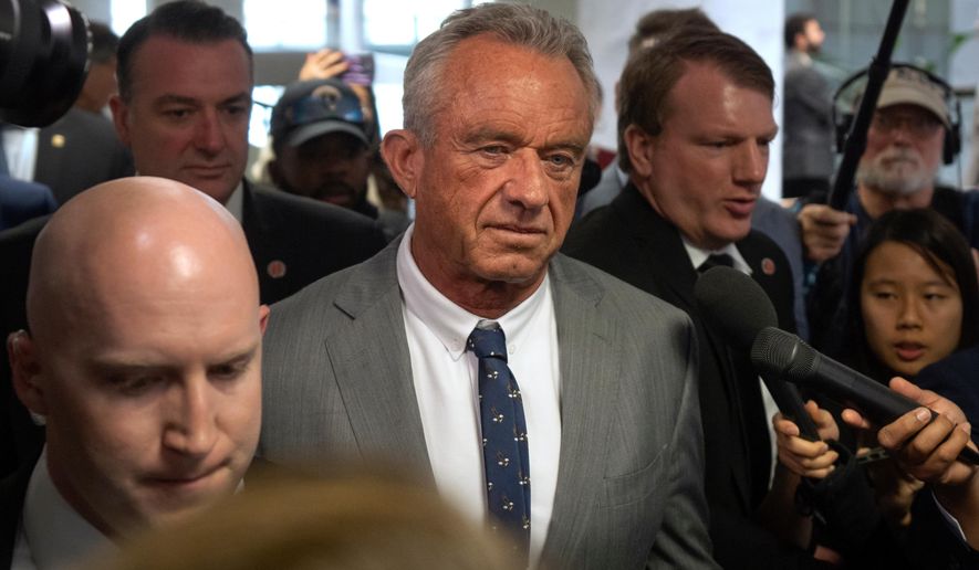 Robert Kennedy Jr., center, President-elect Donald Trump's pick to lead the Health and Human Services Department, walks between meetings with senators on Capitol Hill, Tuesday, Dec. 17, 2024, in Washington. (AP Photo/Mark Schiefelbein, File)