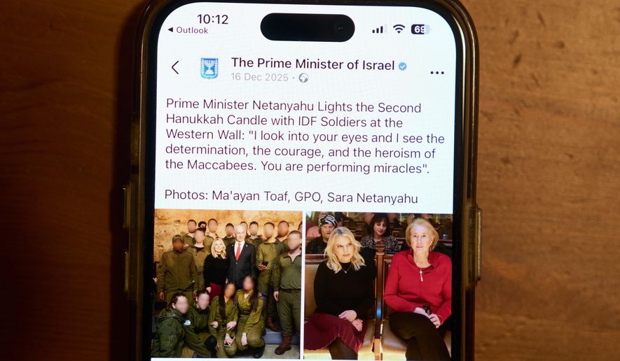 A Facebook post of the Prime Minister of Israel with a retouched photo of the Prime Minister’s wife, Sara Netanyahu, is displayed on a phone in Ramat Gan, Israel, Jan, 9, 2026 (AP Photo/Oded Balilty)