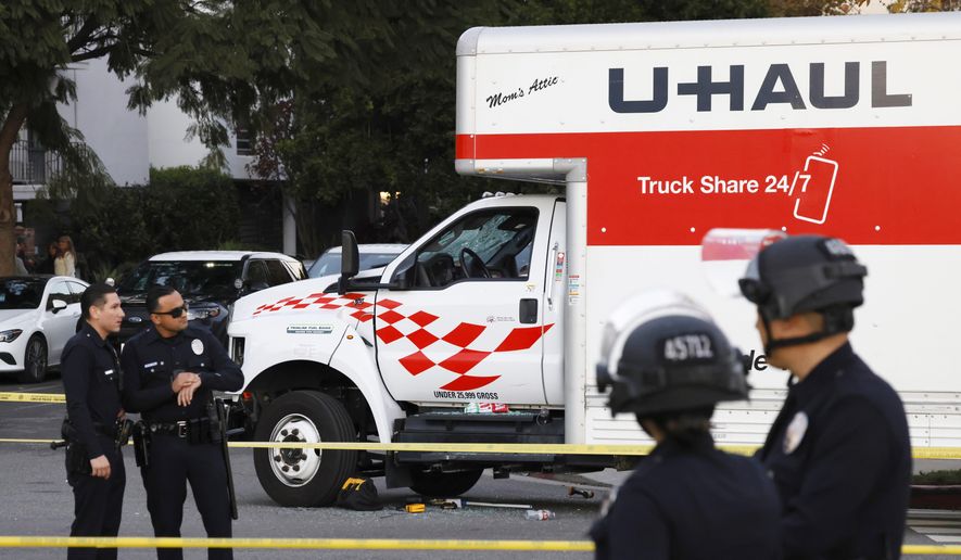 A U-Haul truck, which was driven into a group of protesters, is surrounded by LAPD officers after the incident on Jan. 11, 2026, in the Westwood section of Los Angeles. (Kayla Bartkowski/Los Angeles Times via AP)