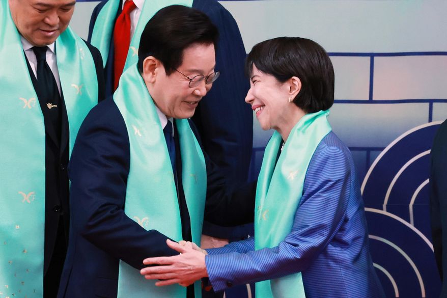 South Korean President Lee Jae-myung, center, shakes hands with Japanese Prime Minister Sanae Takaichi after a group photo at the Asia-Pacific Economic Cooperation (APEC) Economic Leaders' Meeting in Gyeongju, South Korea, Nov. 1, 2025. (Yonhap via AP, File)
