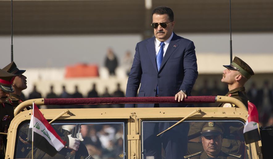 Iraqi Prime Minister Mohammed Shia al-Sudani, center, rides in a Humvee during the Army Day celebrations in Baghdad, Iraq, Tuesday, Jan. 6, 2026. (AP Photo/Hadi Mizban)