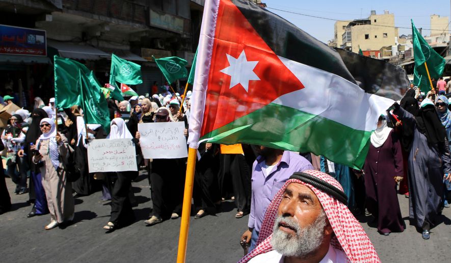 A Jordanian protester carries the national flag during a rally by the Muslim Brotherhood, in Amman, Jordan, July 31, 2015. (AP Photo/Raad Adayleh, File)
