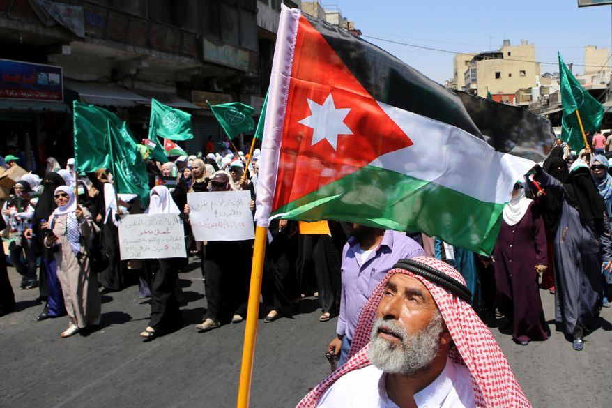 A Jordanian protester carries the national flag during a rally by the Muslim Brotherhood, in Amman, Jordan, July 31, 2015. (AP Photo/Raad Adayleh, File)