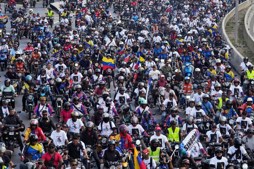 Supporters of former Venezuelan President Nicolas Maduro ride through the streets calling for his release as he faces trial in the United States after being captured by U.S. forces, in Caracas, Venezuela, Tuesday, Jan. 13, 2026. (AP Photo/Matias Delacroix)