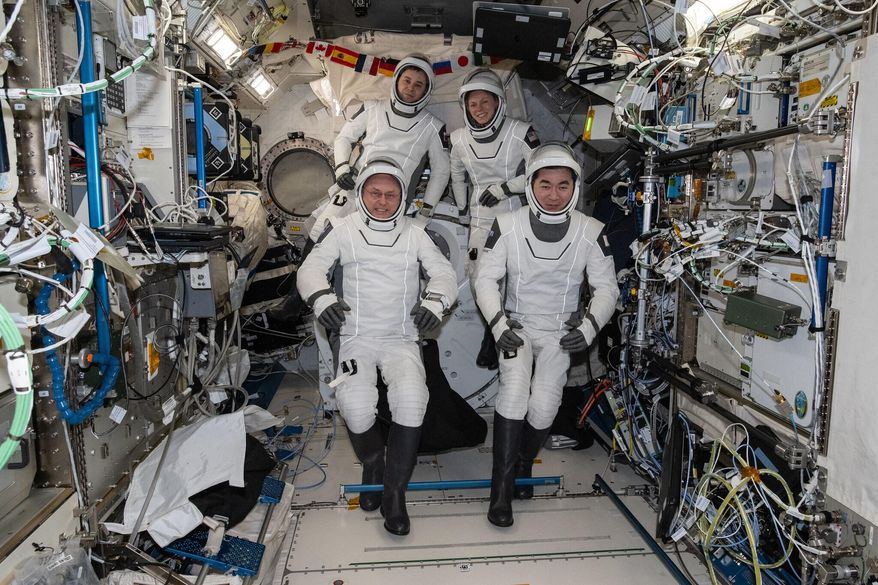 This photo provided by NASA shows clockwise from bottom left are, NASA astronaut Mike Fincke, Roscosmos cosmonaut Oleg Platonov, NASA astronaut Zena Cardman, and JAXA (Japan Aerospace Exploration Agency) astronaut Kimiya Yui gathering for a crew portrait wearing their Dragon pressure suits during a suit verification check inside the International Space Station’s Kibo laboratory module, Wednesday, Jan. 14, 2026. (NASA via AP)