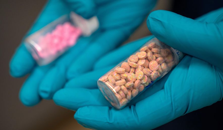FILE - Jonathan Dumke, a senior forensic chemist with the Drug Enforcement Administration, holds vials of fentanyl pills at a DEA research laboratory on Tuesday, April 29, 2025, in Northern Virginia. (AP Photo/Mark Schiefelbein, file)