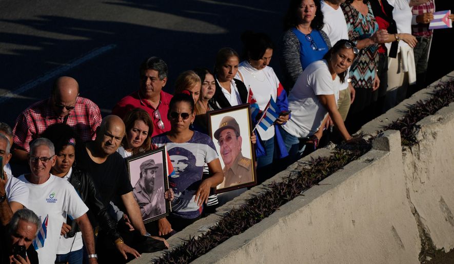 People line the streets of Havana, Cuba, Thursday, Jan. 15, 2026, to watch the motorcade carrying urns containing the remains of Cuban officers killed during the U.S. operation in Venezuela that captured Venezuelan President Nicolas Maduro. (AP Photo/Ramon Espinosa)