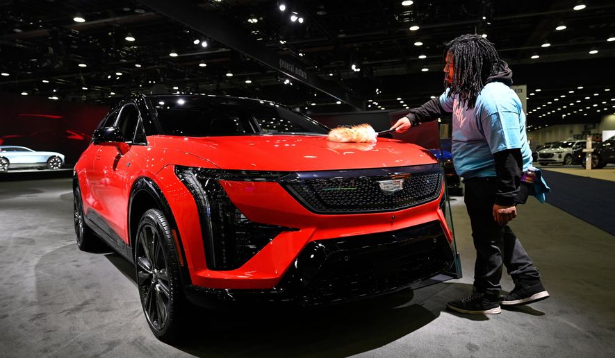 A worker dusts on a 2026 Cadillac Optiq Premium Sport vehicle at the Detroit Auto Show, Wednesday, Jan. 14, 2026, in Detroit. (AP Photo/Jose Juarez)