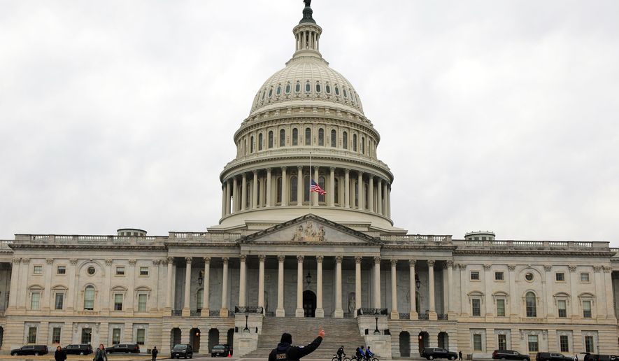 A U.S. Capitol Police officer patrols on the East Front of the U.S. Capitol, Wednesday, Jan. 14, 2026, in Washington. (AP Photo/Rahmat Gul)