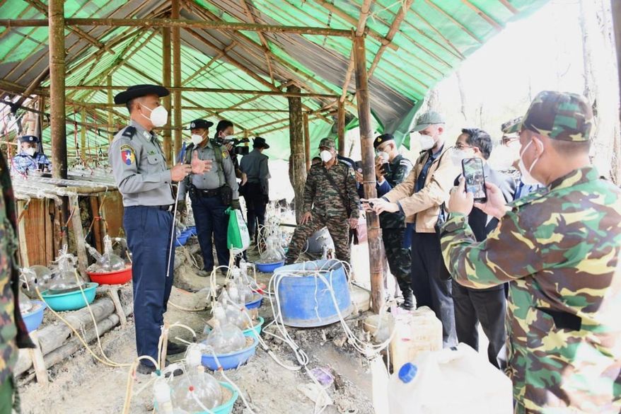 In this photo provided by Myanmar Military True News Information Team on Wednesday, Jan. 14, 2025, police officer explains diplomats and journalists at drug seizure site near Mongyai township, Shan State, Myanmar. (Myanmar Military True News Information Team via AP)