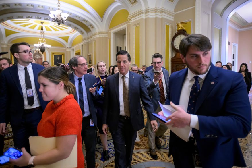 Sen. Bernie Moreno, R-Ohio, center, talks with reporters as he walks through the Ohio Clock Corridor at the Capitol, Tuesday, Jan. 13, 2026, in Washington. (AP Photo/Rod Lamkey, Jr.)