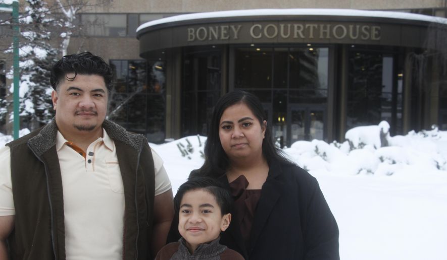 Michael Pese, left, his wife, Tupe Smith, and their son Maximus pose for a photo outside the Boney Courthouse in Anchorage, Alaska, Thursday, Jan. 15, 2026, ahead of the Alaska Court of Appeals hearing a challenge to the voter fraud case brought against her by the state. (AP Photo/Mark Thiessen)