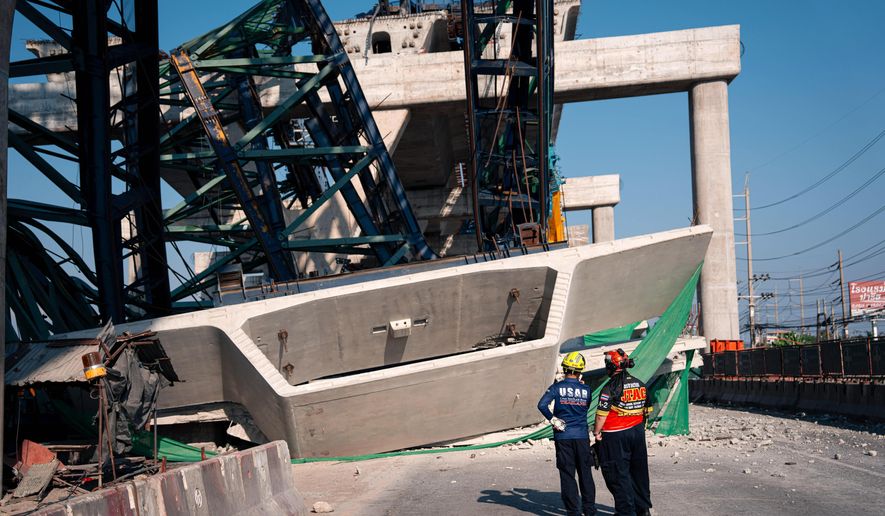 Rescuers look at a construction crane that collapsed on the Rama 2 Road elevated expressway in Samut Sakhon province, Thailand on Thursday, Jan. 15, 2026. (AP Photo/Arnun Chonmahatrakool)