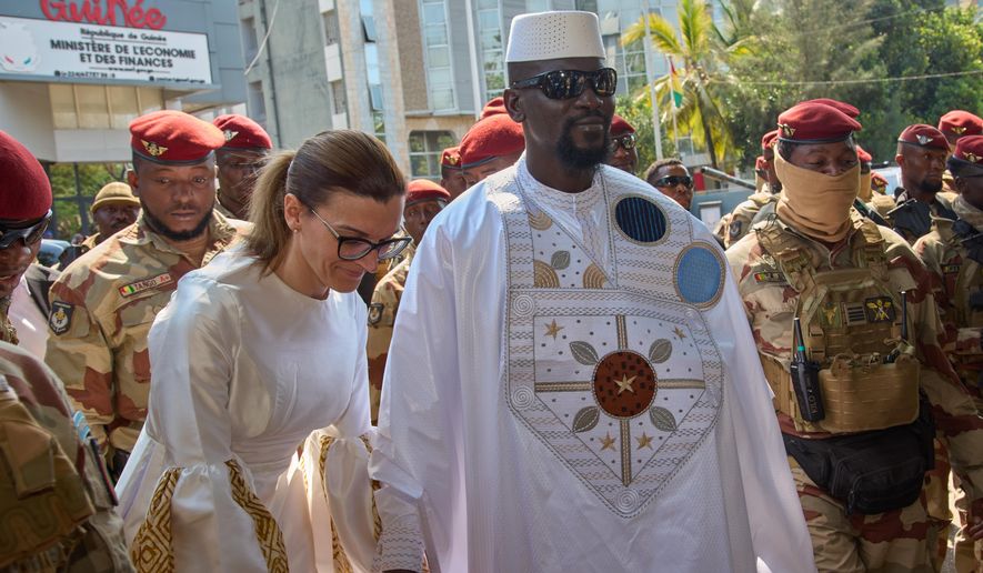 Guinea's President, Gen. Mamadi Doumbouya, arrives with his wife, Lauriane Doumbouya, to cast their votes in the presidential election in Conakry, Guinea, Sunday, Dec. 28, 2025. (AP Photo/Fode Toure)