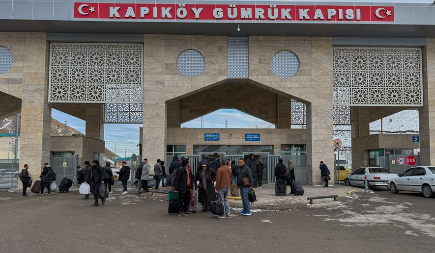 People, mostly Iranians, wait after crossing Kapikoy border post between Turkey and Iran, in Kapikoy, Turkey, Saturday, Jan. 17, 2026. (AP Photo/Serra Yedikardes)