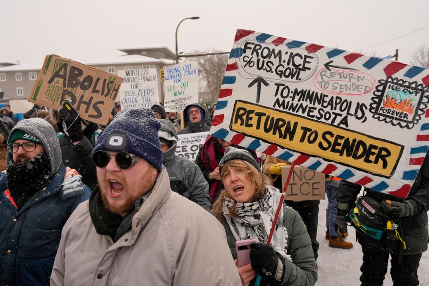 People march and gather near the post office during a protest, Sunday, Jan. 18, 2026, in Minneapolis. (AP Photo/Yuki Iwamura)